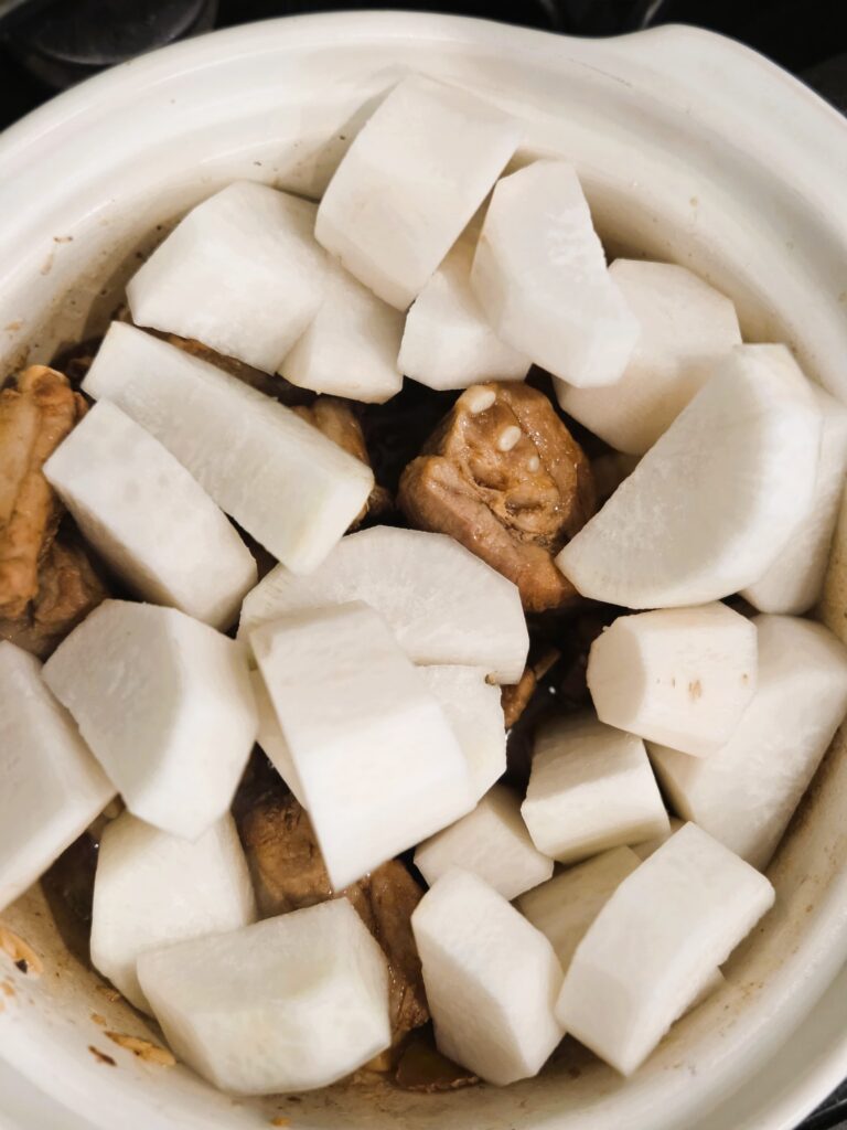 Adding in the daikon after pork spareribs are golden seared